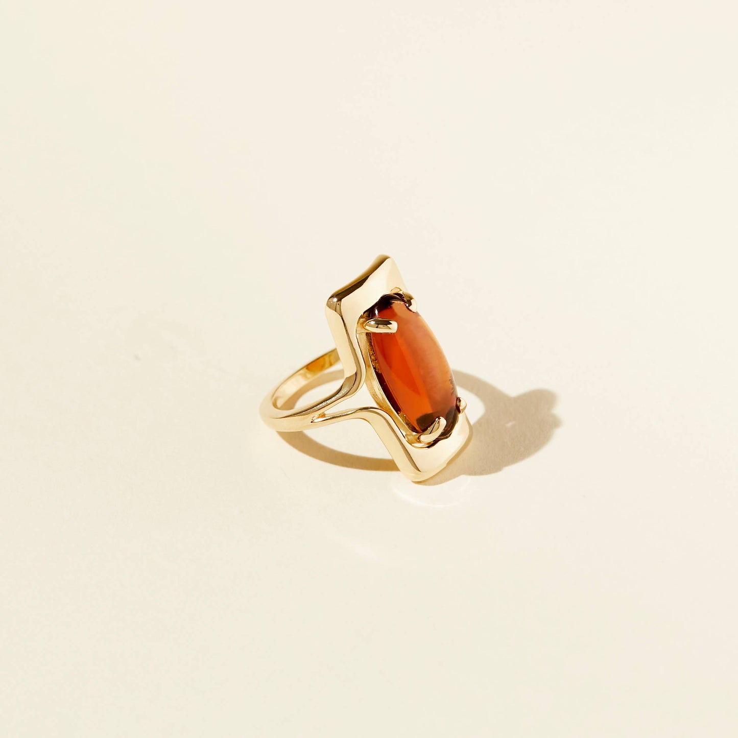 angled side view of the amber walton ring on a beige background