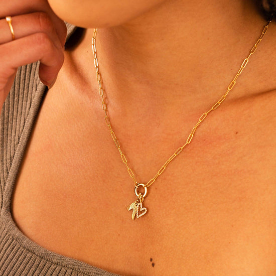 close up of a model wearing the paperclip chain charm necklace with two gold charms attached