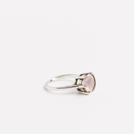 side view of the rose quartz half bezel ring on a white bavckground
