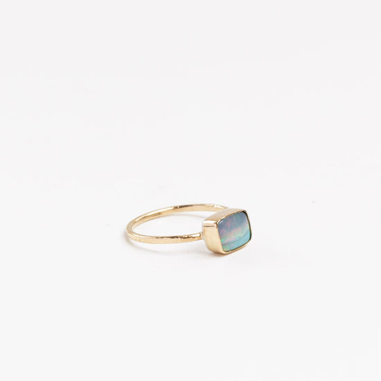 side view of the opal square solitaire ring on a white background