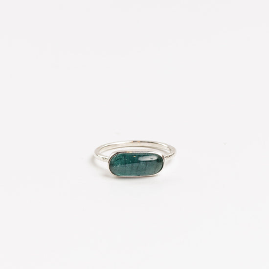 oval cabochon aquamarine bezel set in sterling silver ring on a white background