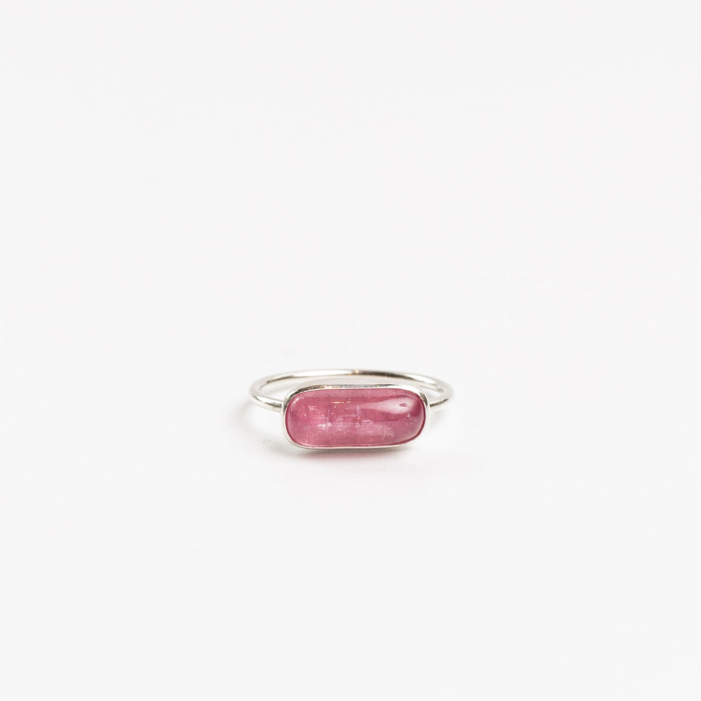 sterling silver ring with bezel set pink tourmaline on a white background