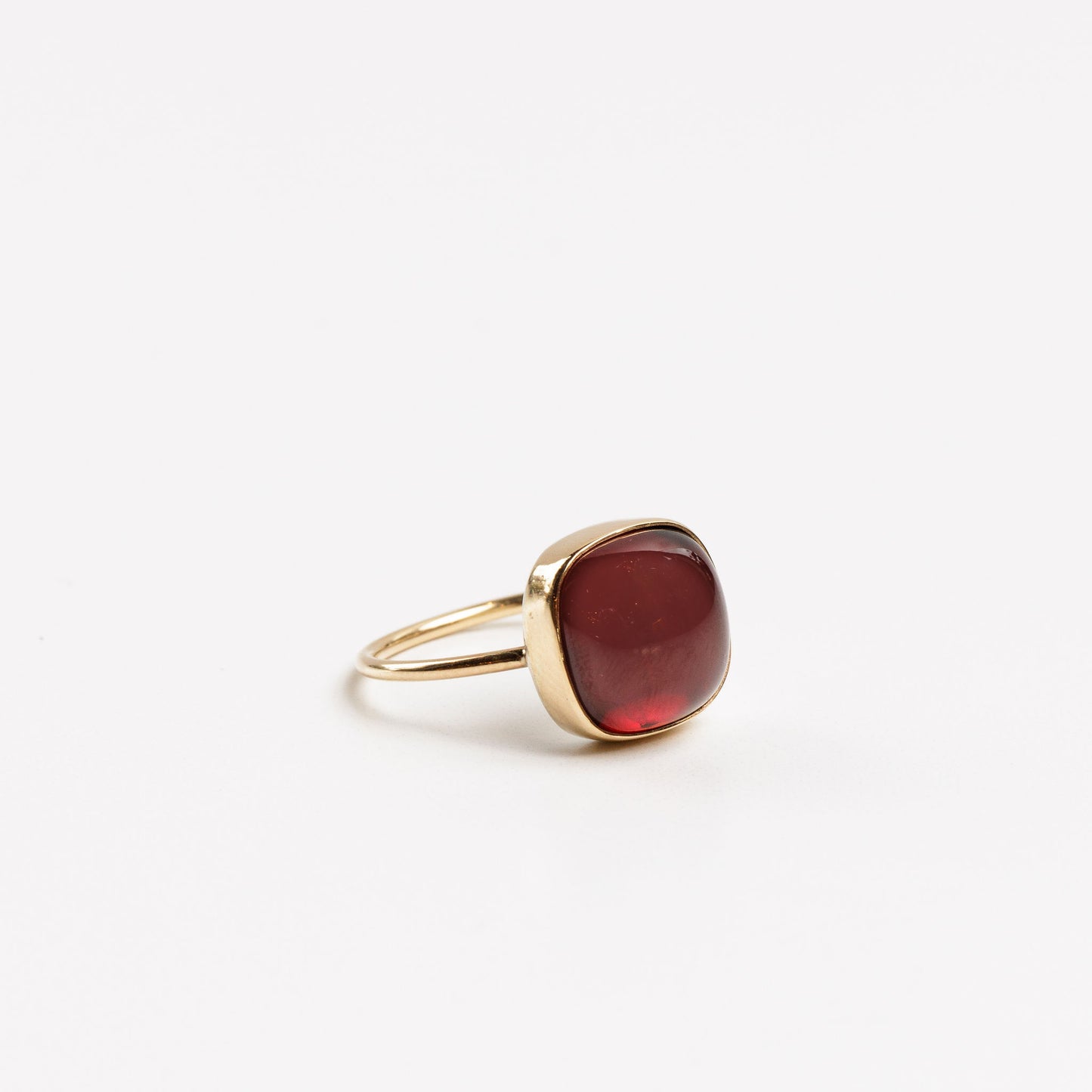 side view of the garnet cabochan ring on a white background
