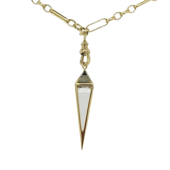 crystal pendulum shaped gold pendant hanging from a gold link chain close up on a white background