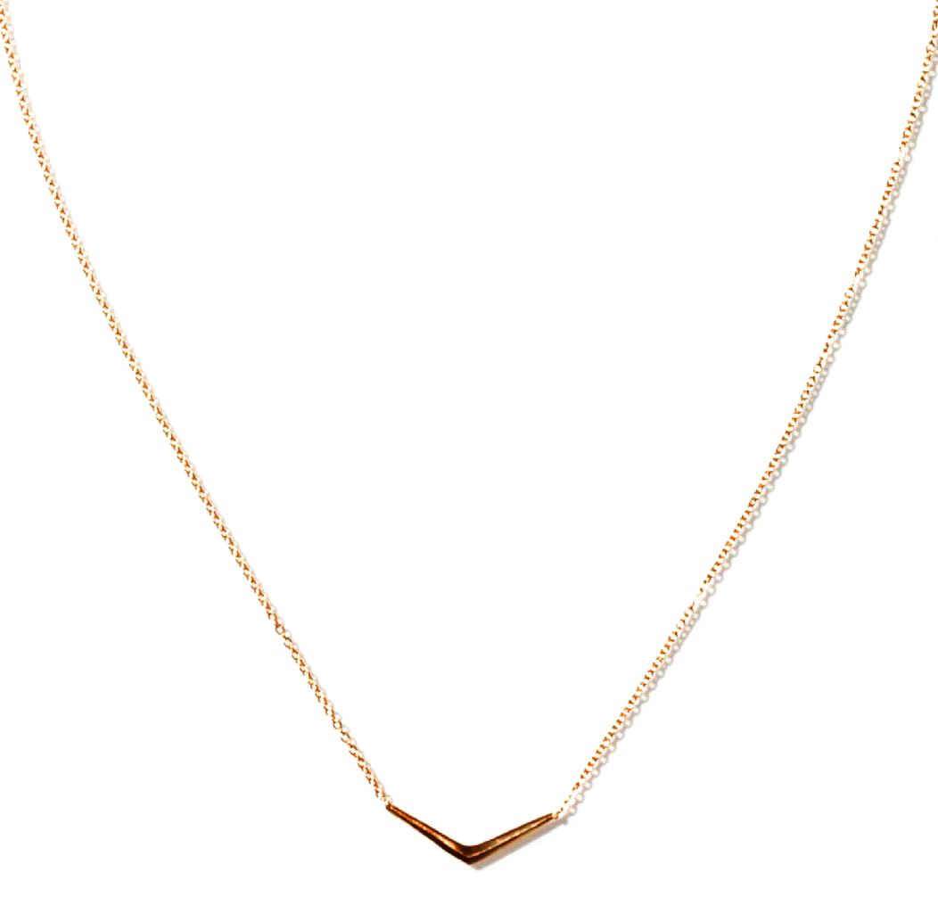 a gold ray pendant necklace on a white background