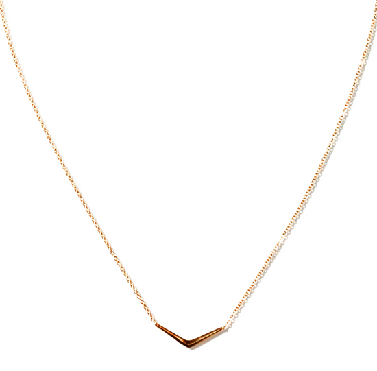 a gold ray pendant necklace on a white background