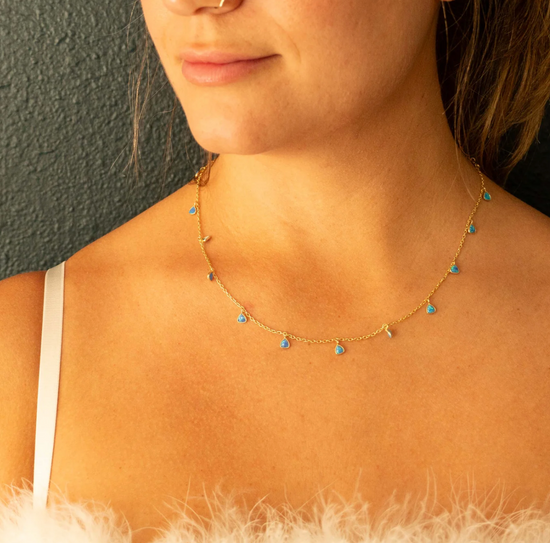 close up of a model wearing the blue opal trillium necklace