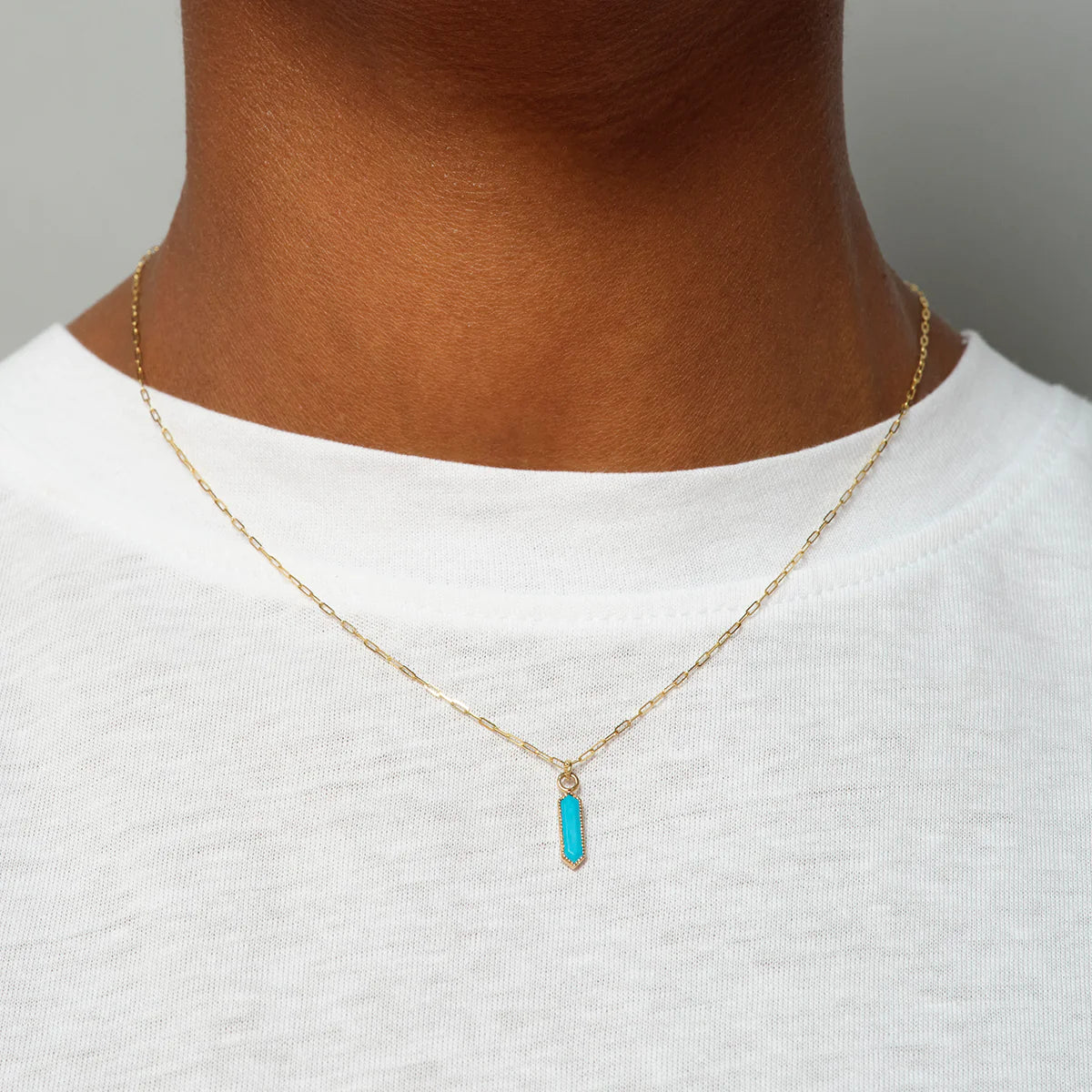 close up of a model wearing the hexa turquoise pendant