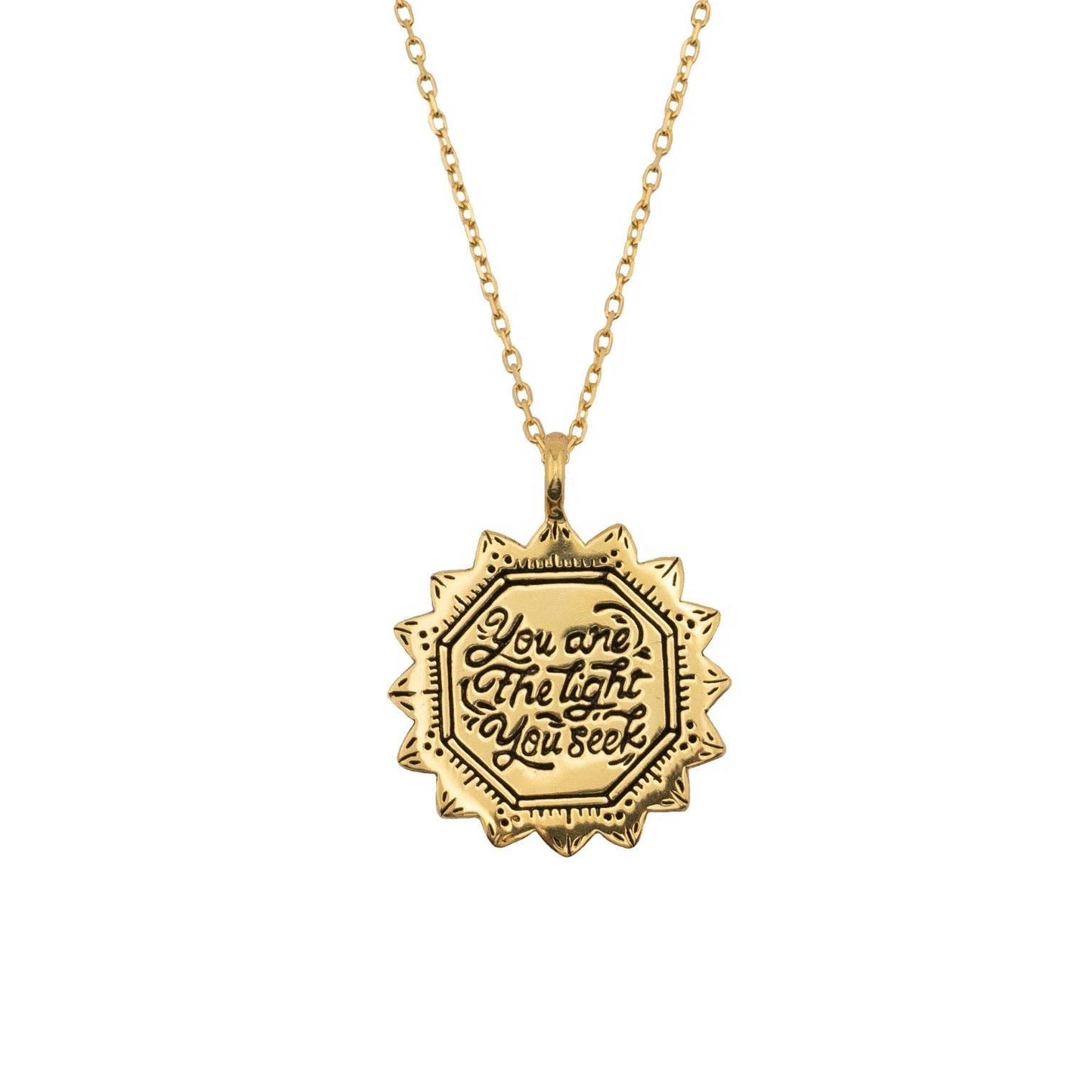 Gold necklace with a hexagonal pendant on a white background