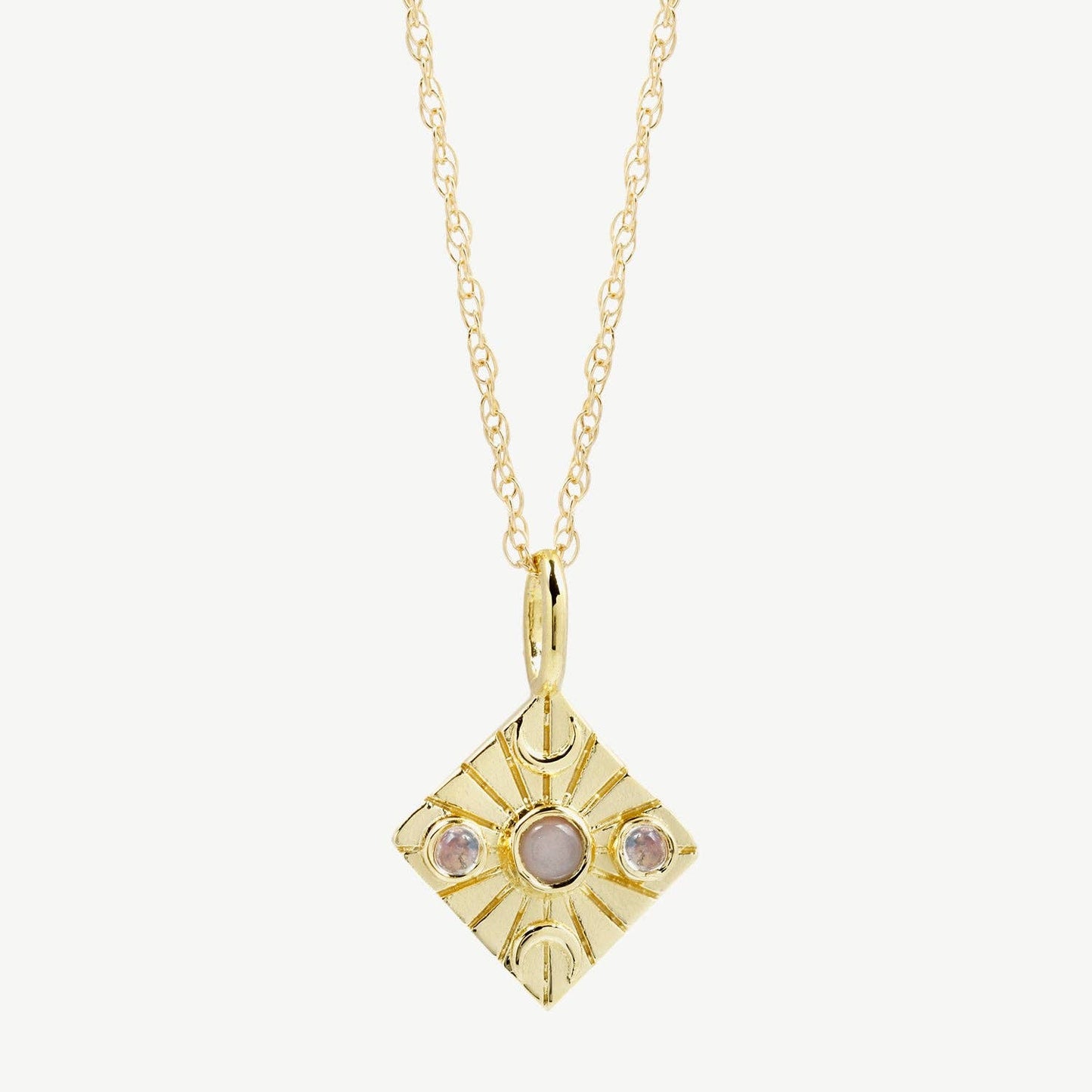 Gold pendant necklace with a central gemstone on a white background