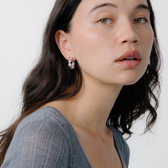 Woman wearing a gray top against a white background