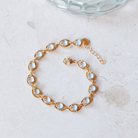 Gold bracelet with glass stones on a light background