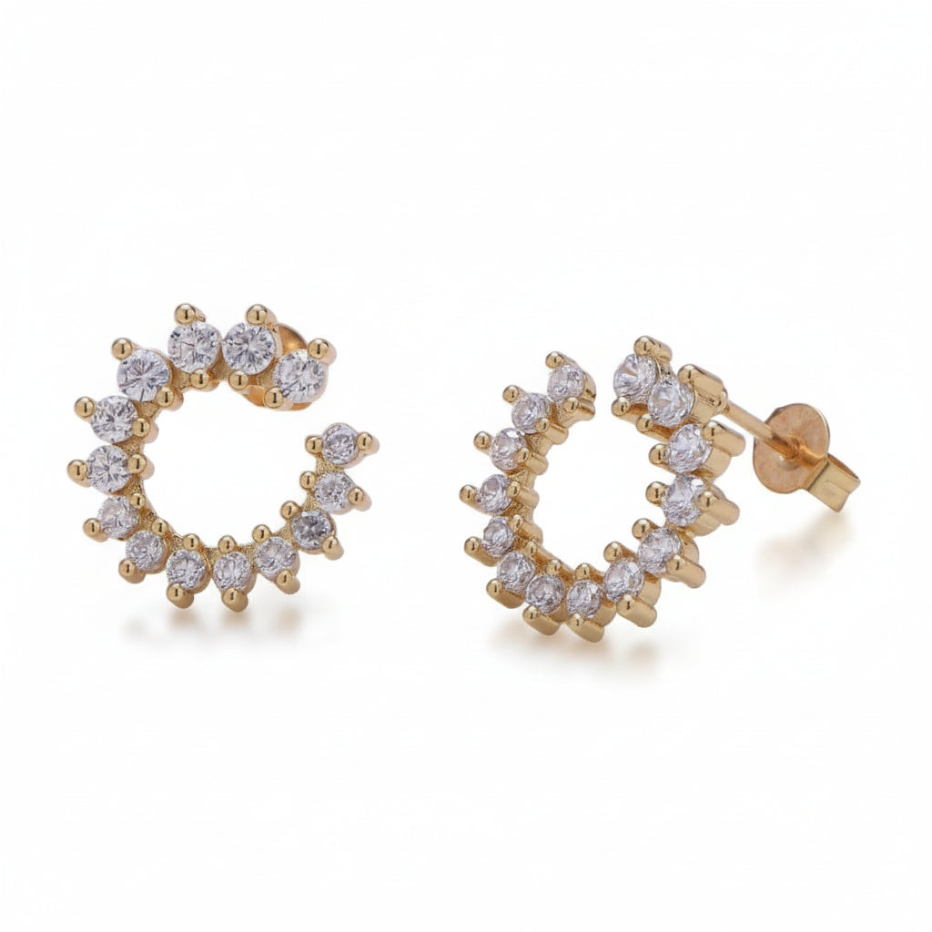Gold hoop earrings with clear gemstones on a light gray background