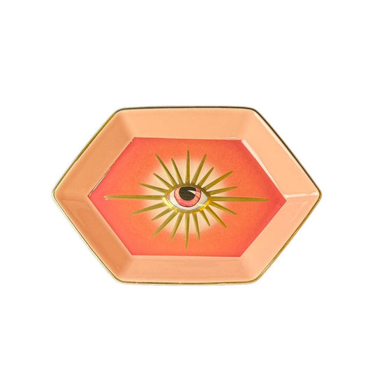 hexagon shaped pink trinket dish with a golden evil eye on a white background