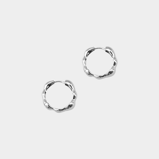 Pair of silver hoop earrings on a white background
