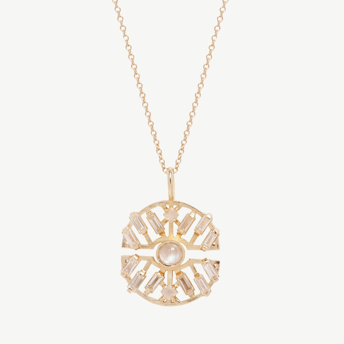 Gold necklace with a decorative pendant on a light pink background