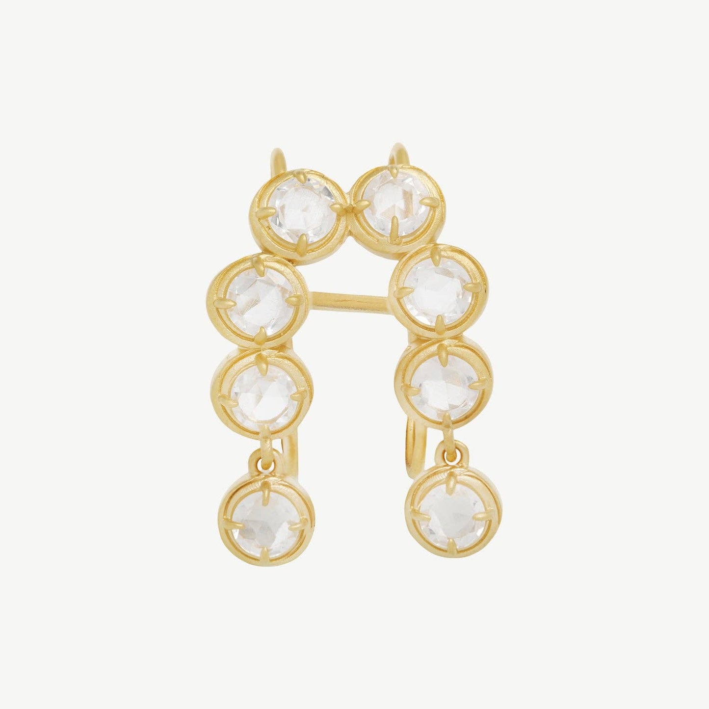 Gold earrings with clear gemstones on a white background