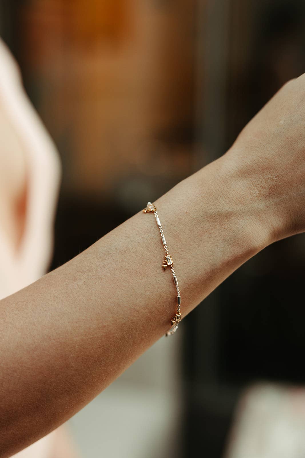 Rose gold bracelet on a wrist with a blurred background