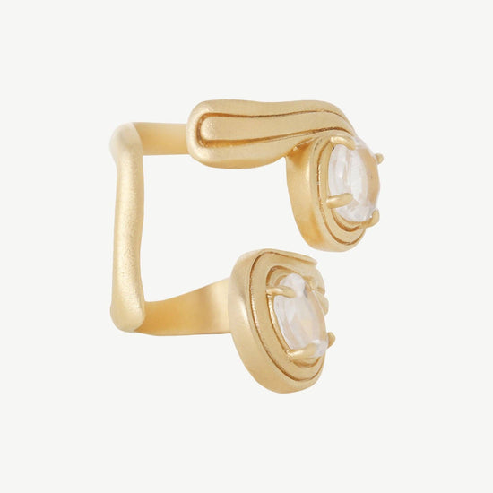 Gold ear cuff with white gemstones on a white background