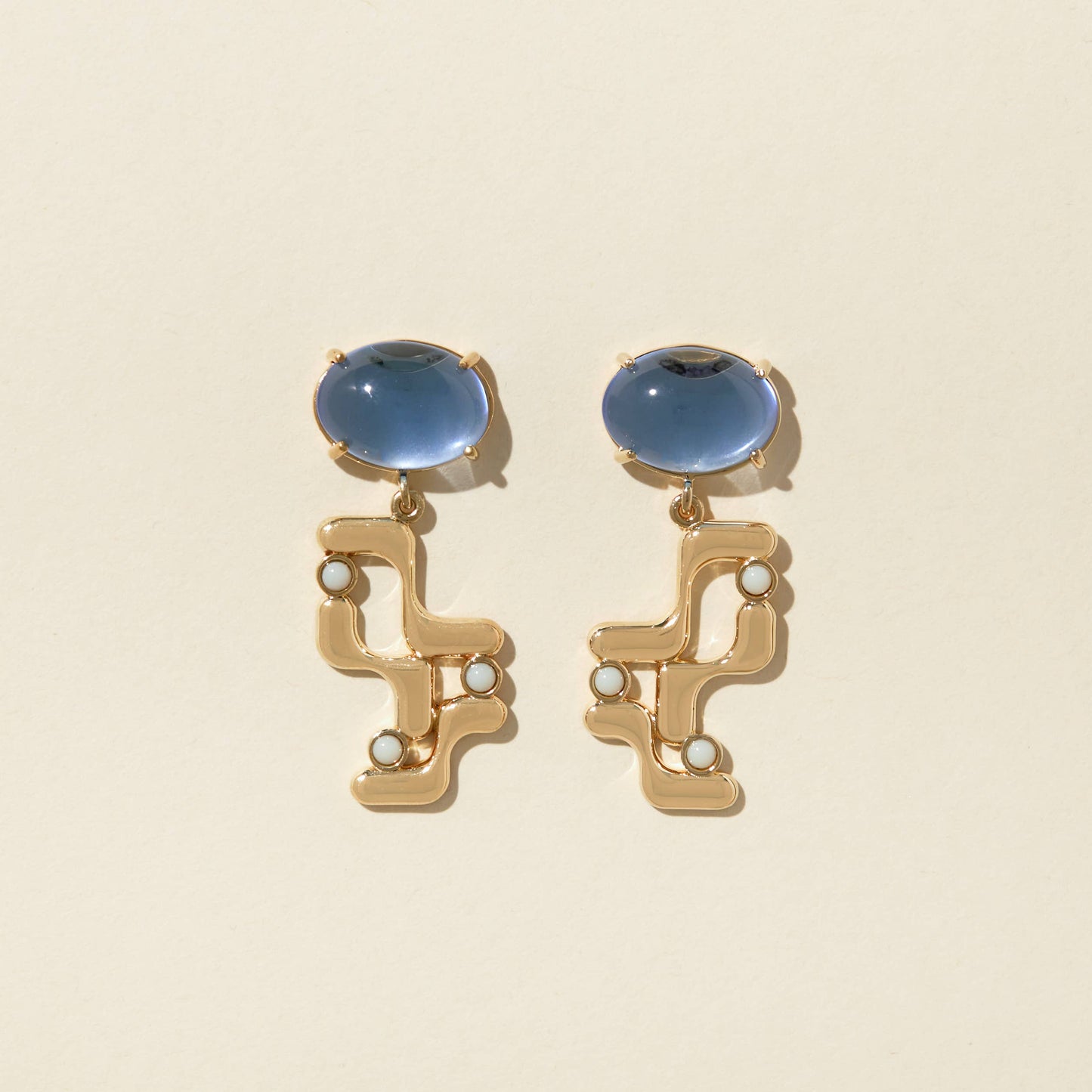 straight front view of the halsted earrings on a beige background