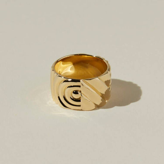 another view of the ribbed and textured design of the chloe ring on a beige background