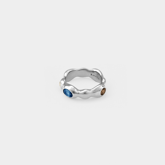 Silver ring with embedded stones on a white background