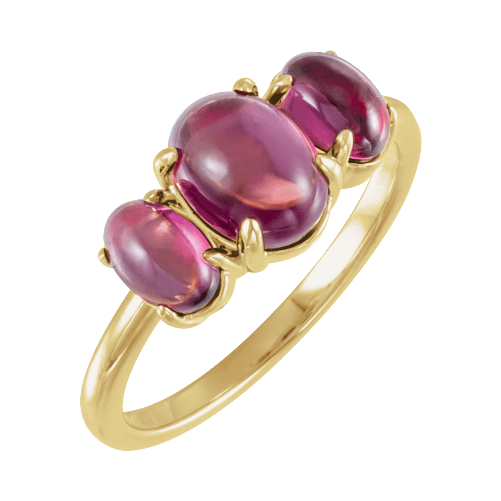 Gold ring with three pink gemstones on a white background