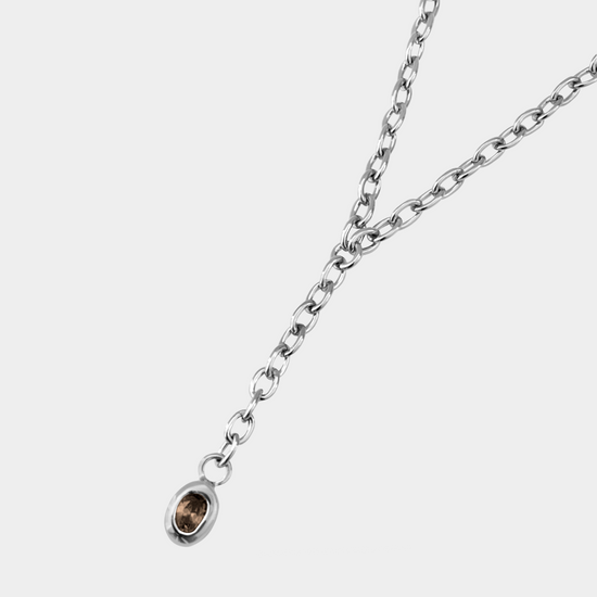 Silver necklace with a small pendant on a white background
