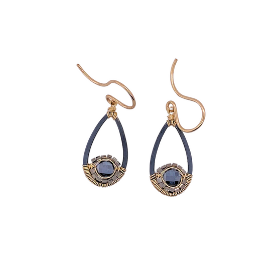 black spinel tear drop shaped earrings with gold and silver details on white background