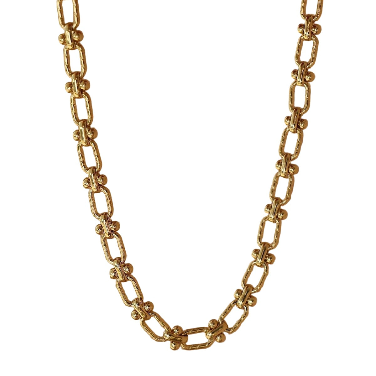 Gold chain necklace on a beige background