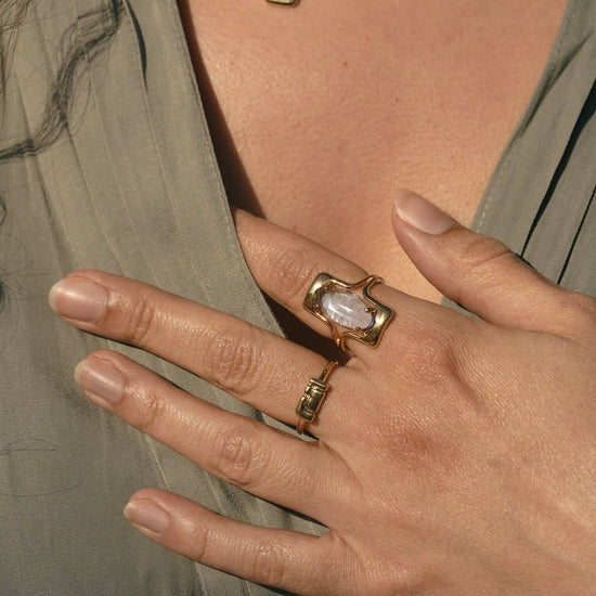 model wearing the blue walton ring on their pointer finger and another gold band on their middle