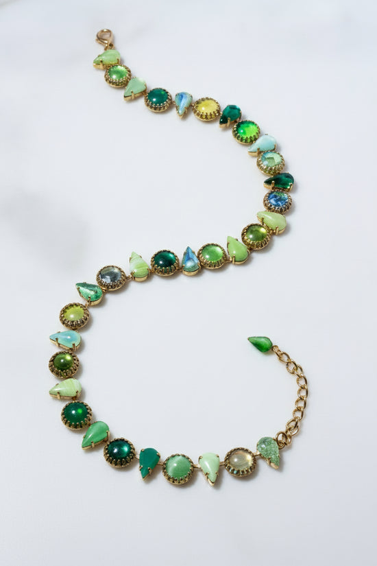 Necklace with green gemstones on a white background