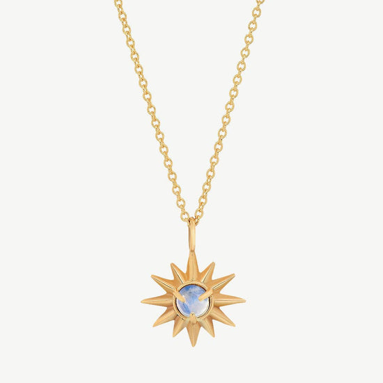 Gold necklace with a sun-shaped pendant on a white background