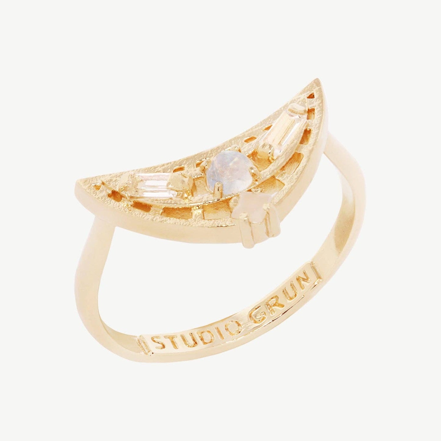 Gold ring with a central gemstone on a white background