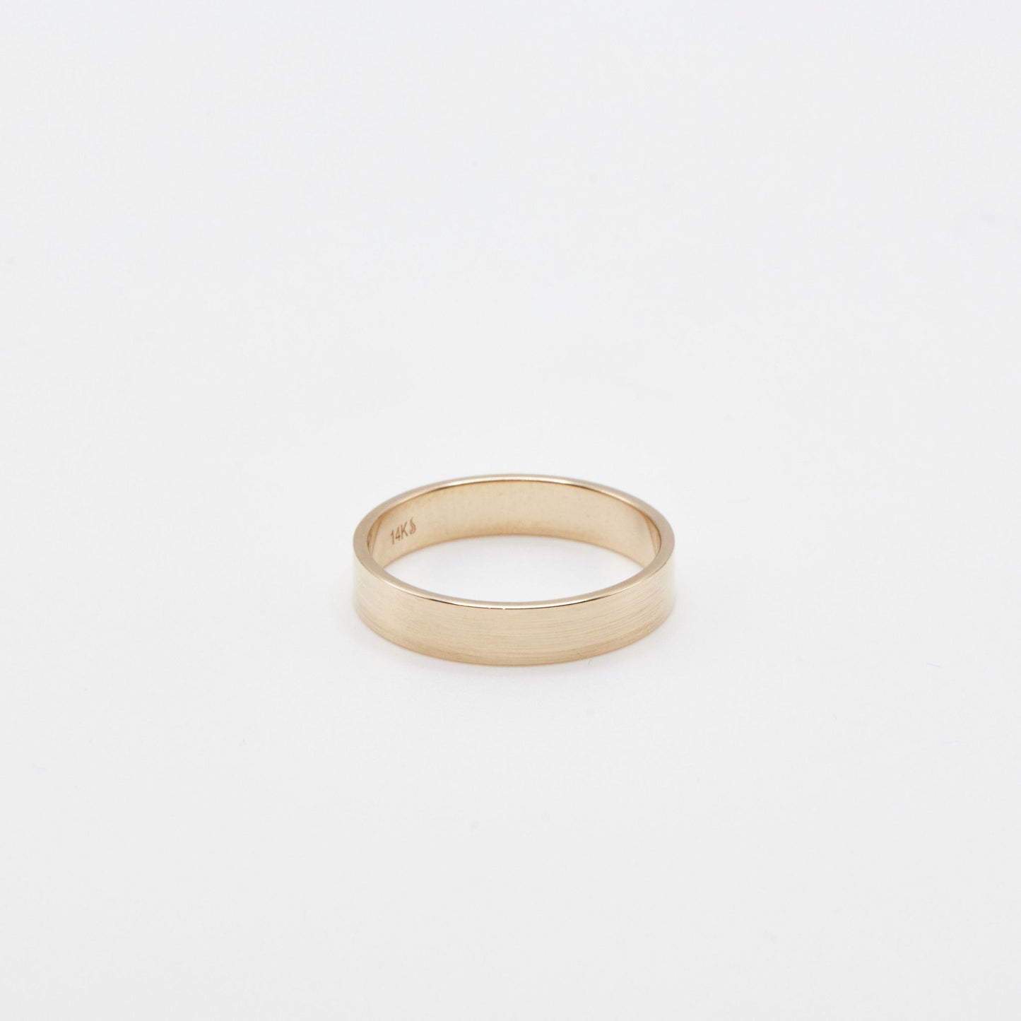 4 mm yellow gold flat wedding band on a white background