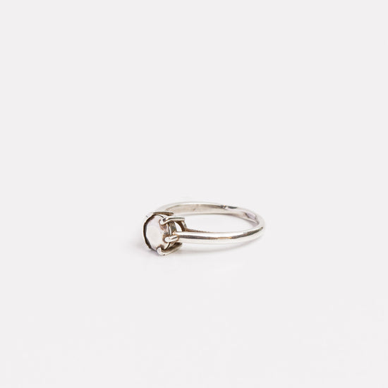 side view of the fine silver half bezel ring on a white background