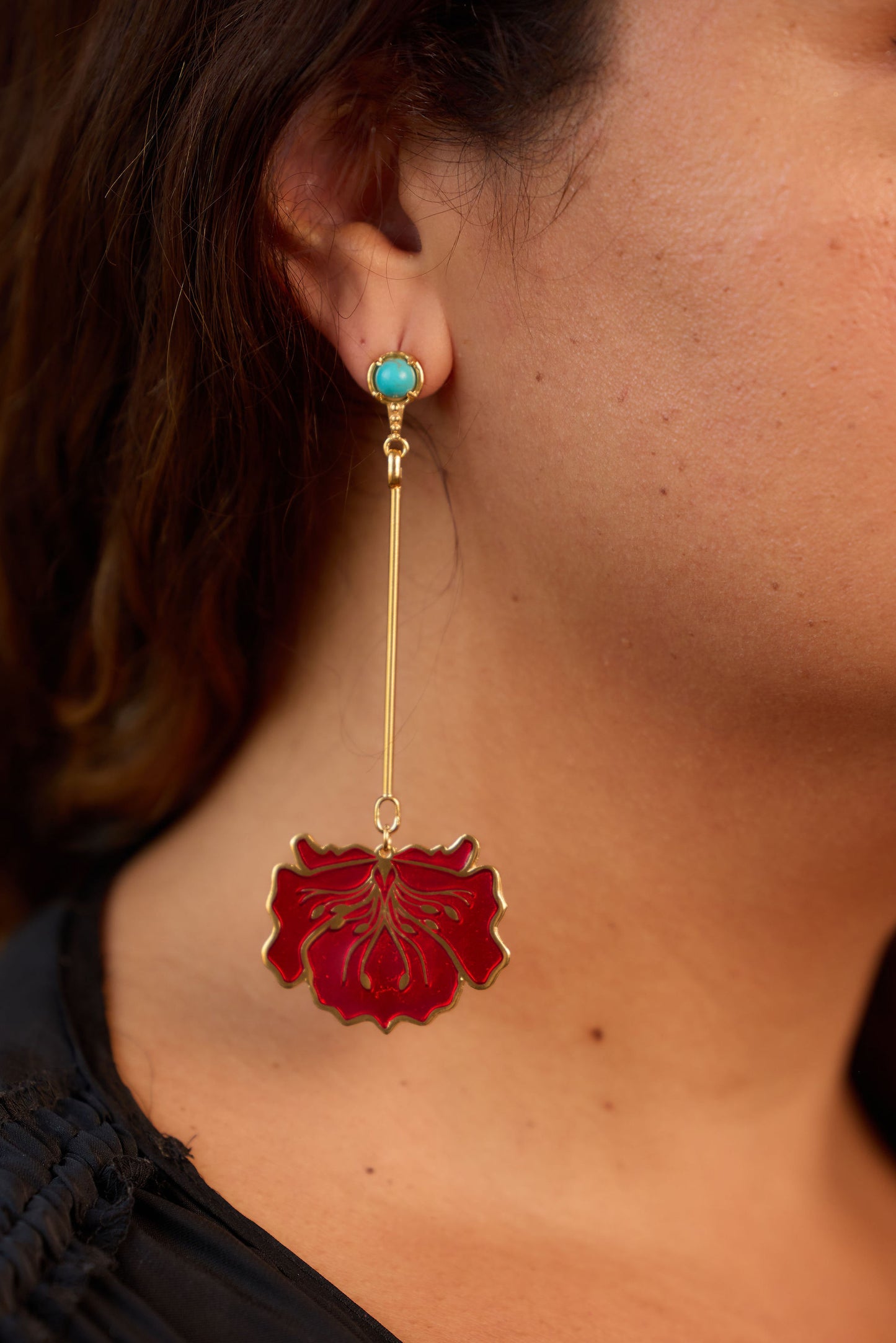 poppy enamel earrings on model in red