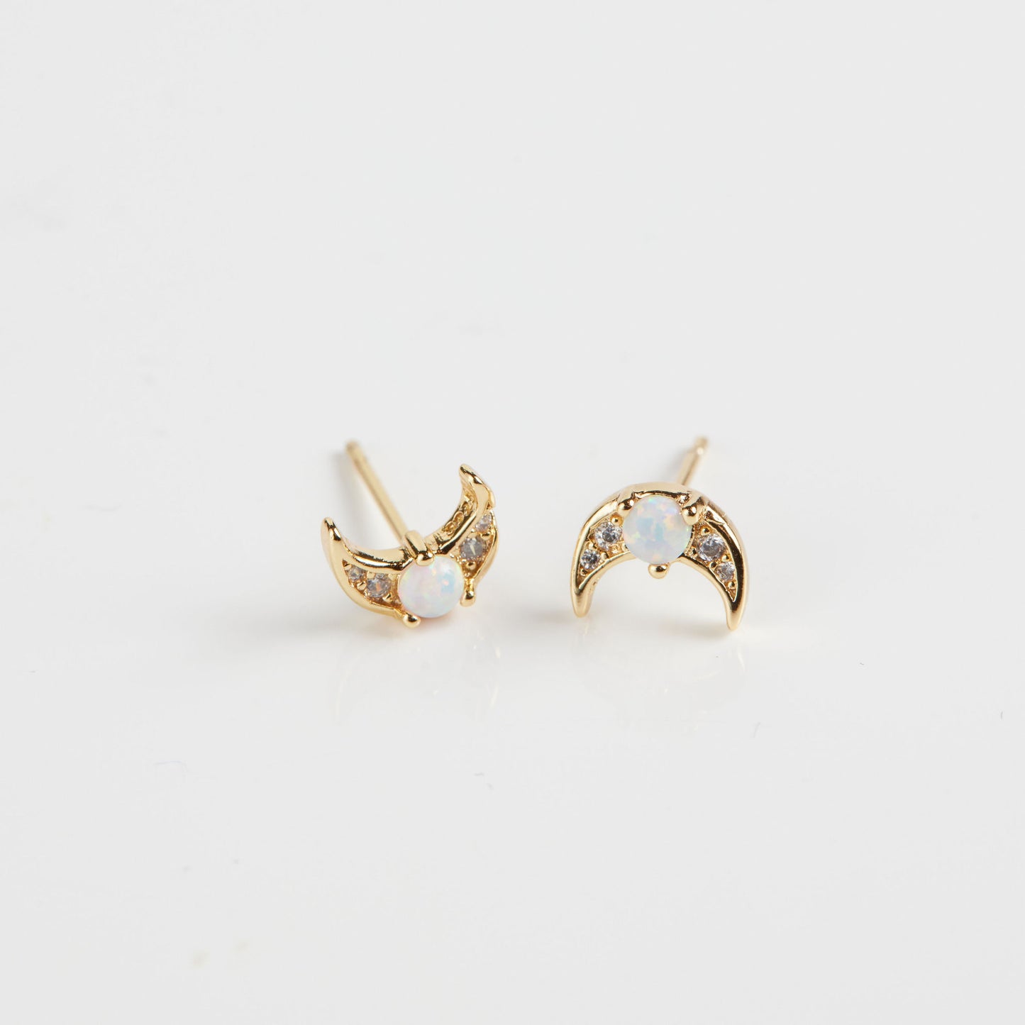 Opal moon crescent studs on white background