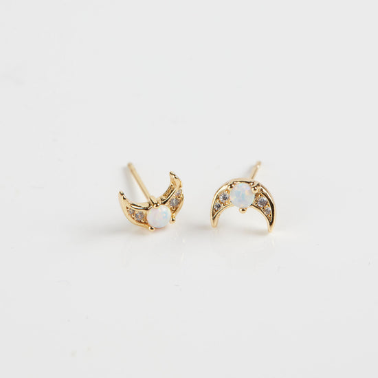 Opal moon crescent studs on white background