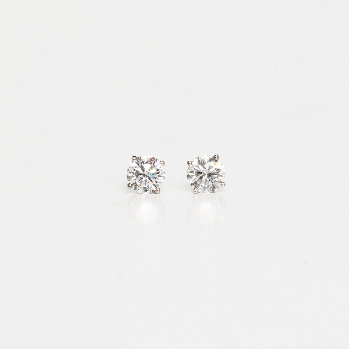 Pair of silver stud earrings on a light gray background