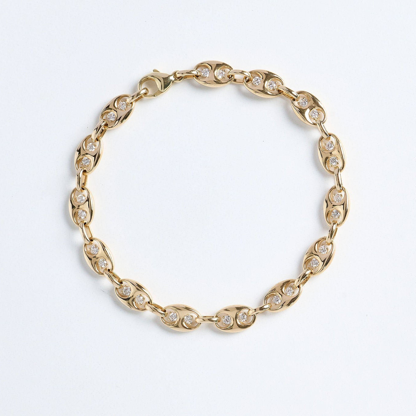 Gold bracelet with clear stones on a light gray background