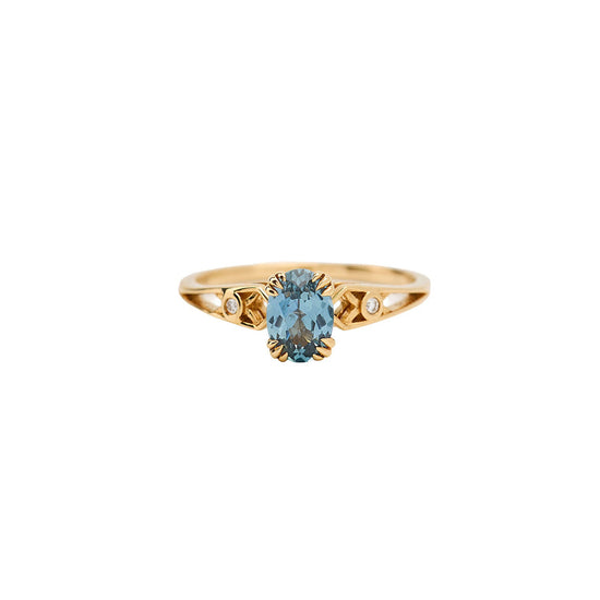 Gold ring with a blue gemstone on a white background