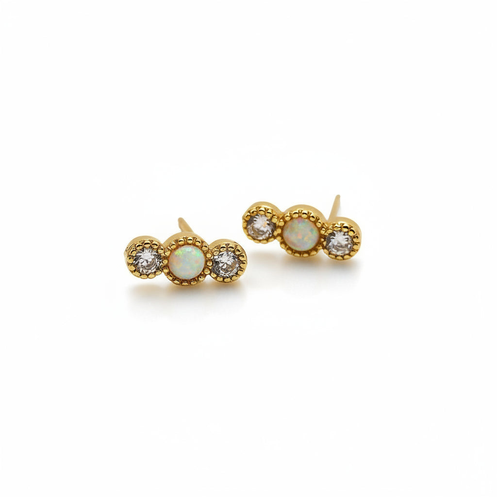 Pair of gold earrings with gemstones on a white background