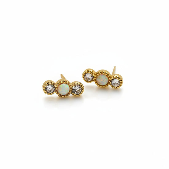 Pair of gold earrings with gemstones on a white background