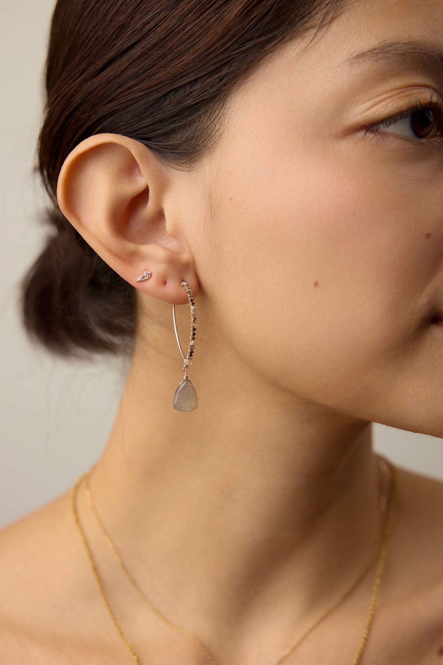 Close up of a person wearing the labradorite beaded hoops