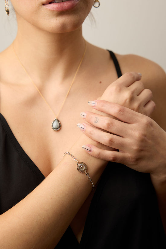 Woman wearing a necklace and bracelet with a neutral background