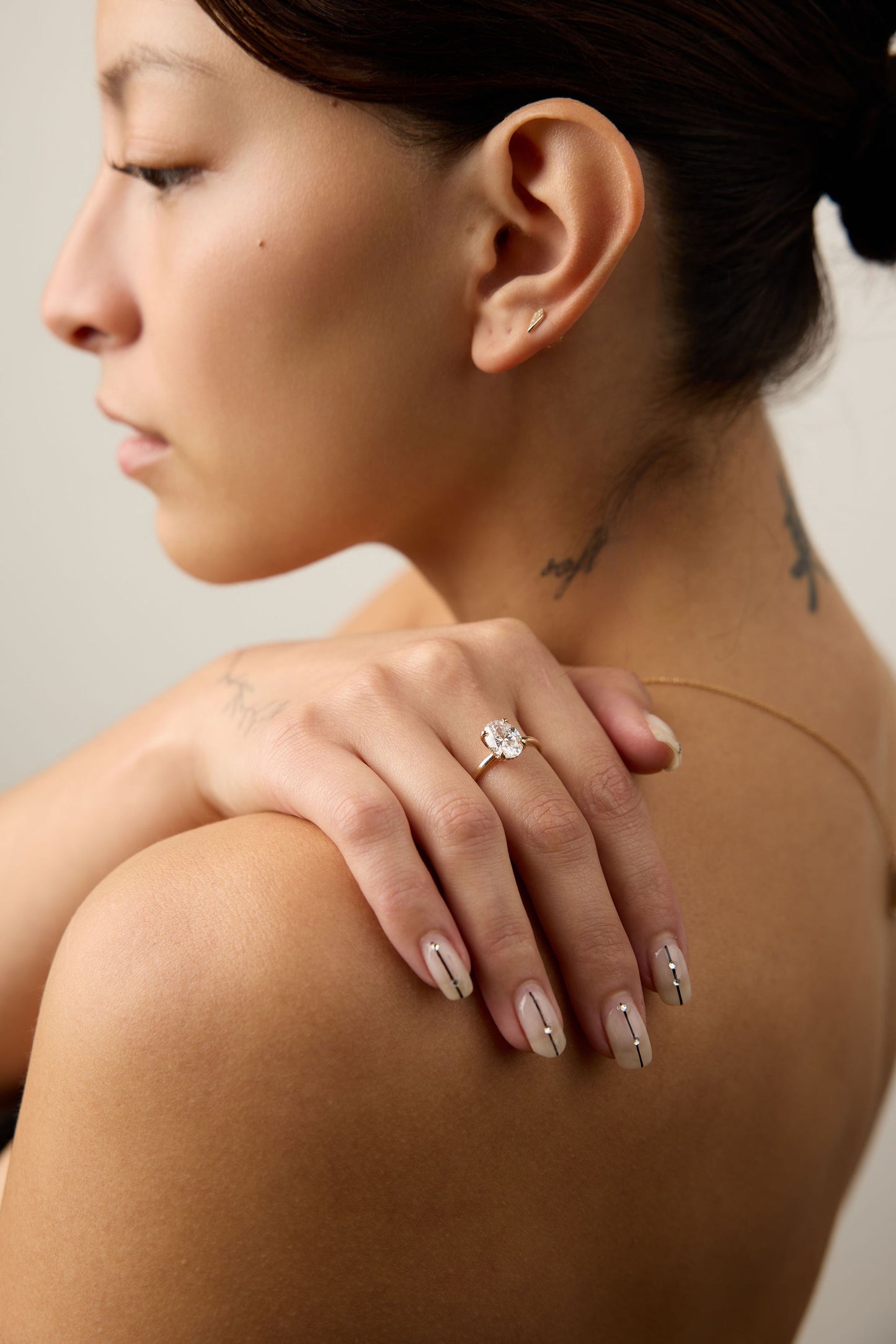 Woman with a diamond ring on her hand, wearing nail polish.