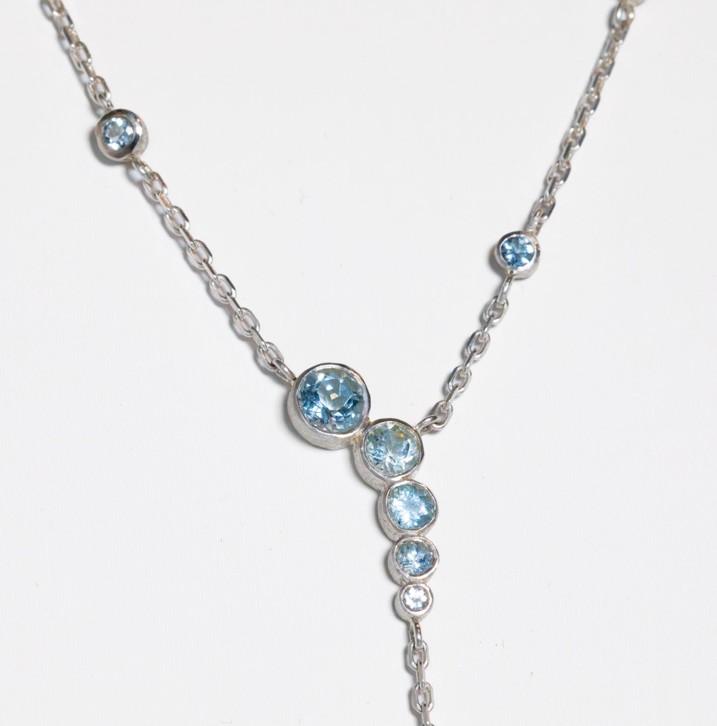 detail shot of plunging aquamarine necklace on white background