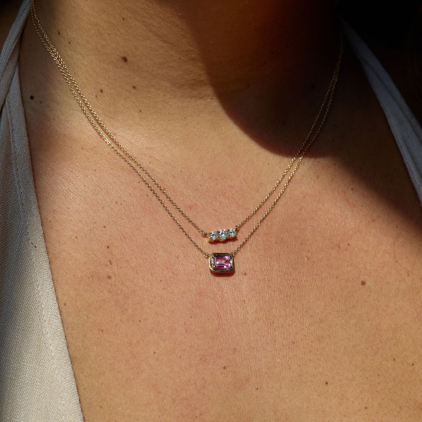 Necklace with pink gemstone pendant on a person's neck