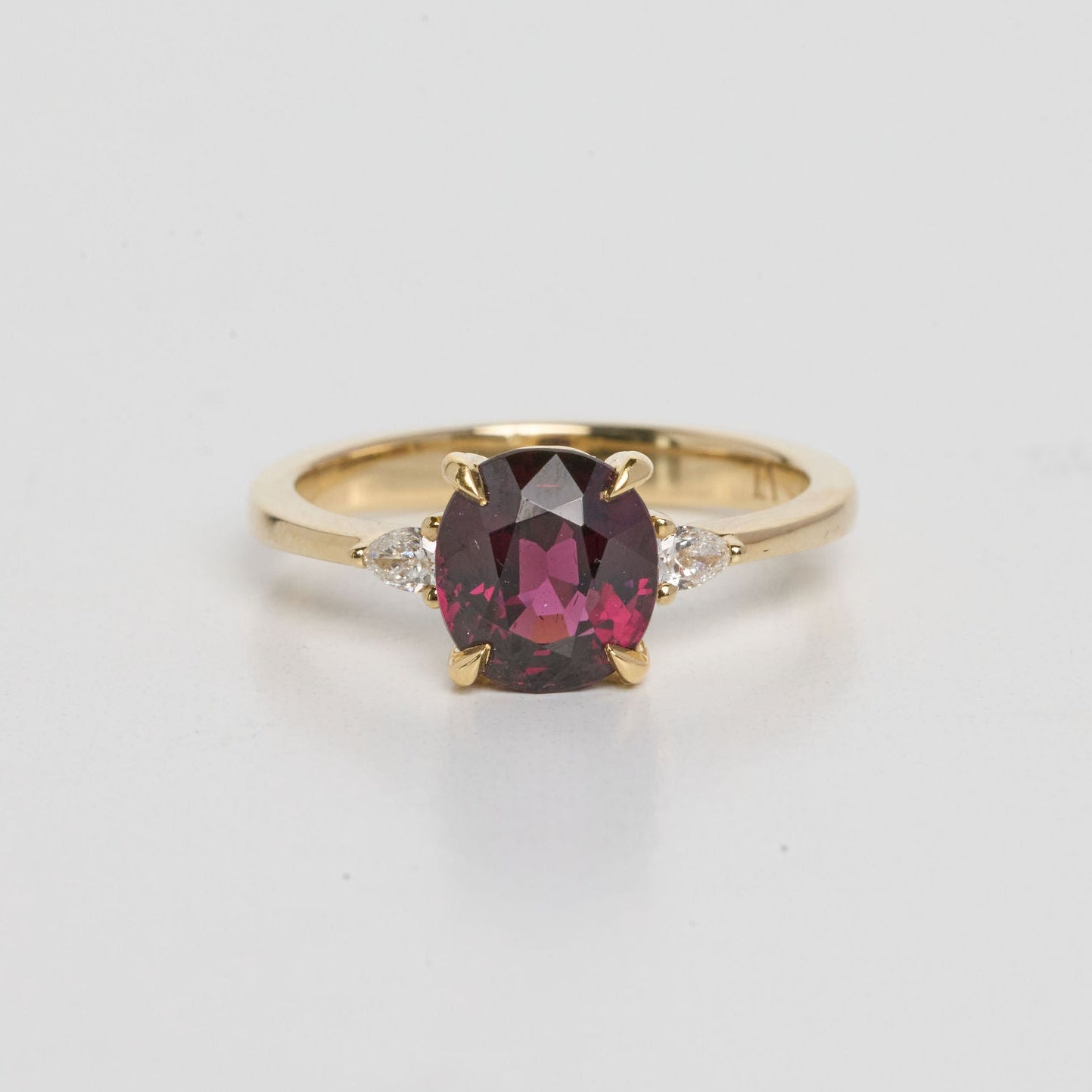 Garnet ring set in 14k yellow gold, photographed on a white background 